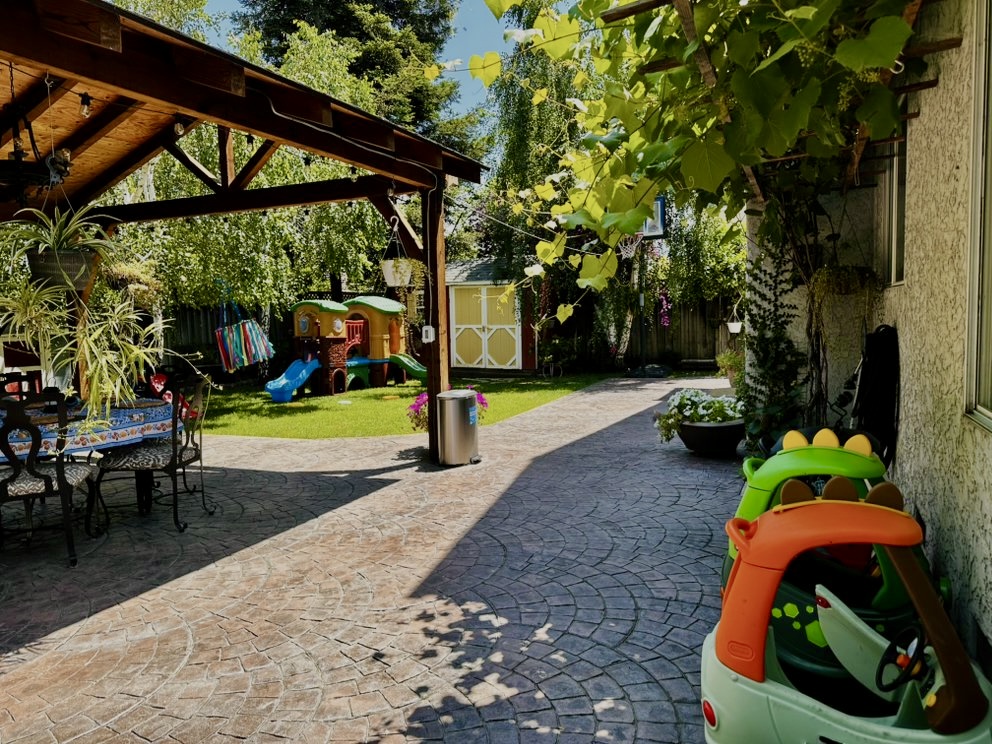 Shaded patio and stamped-concrete play area in the backyard