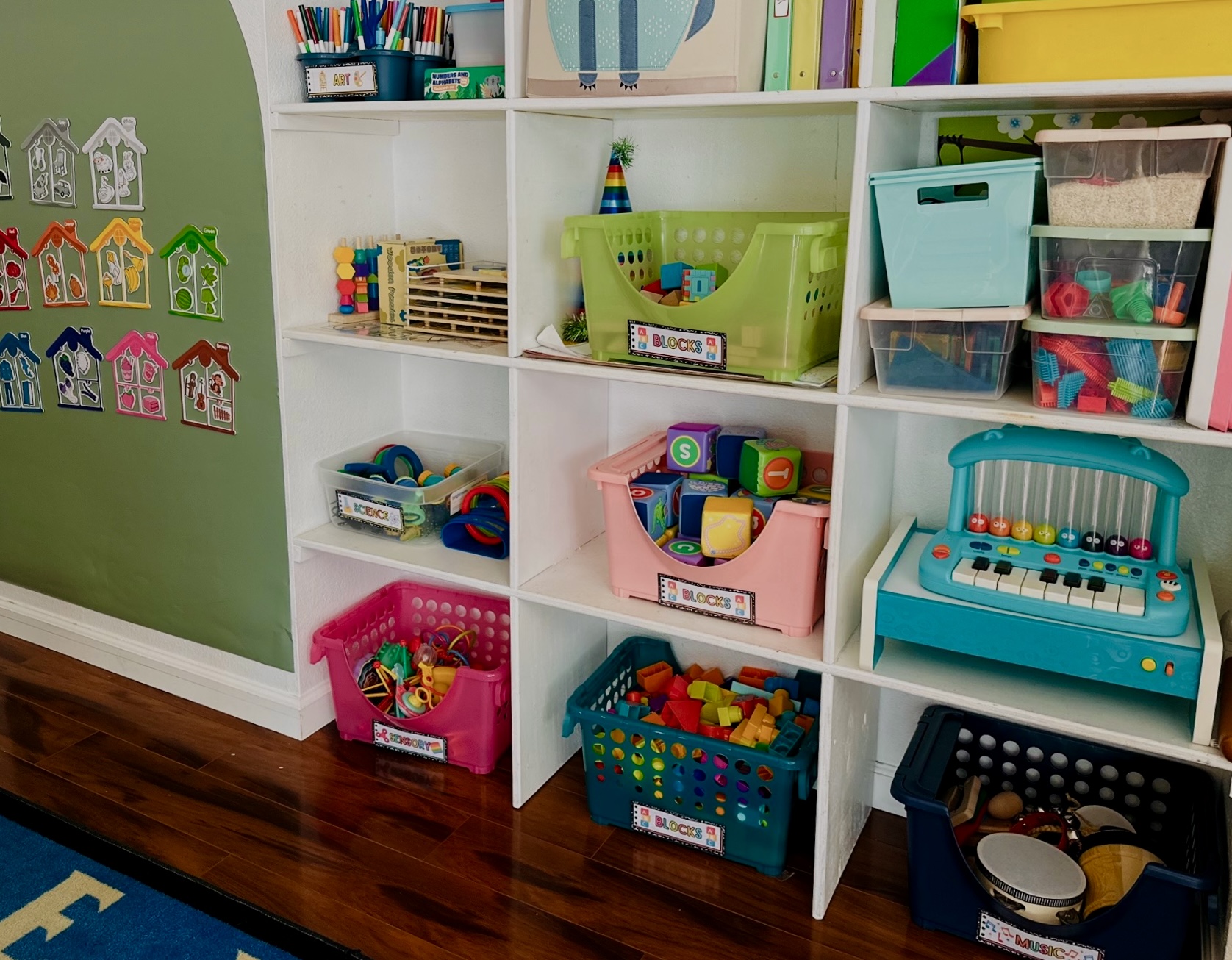 Organized shelves with labeled bins for blocks, art, science and music