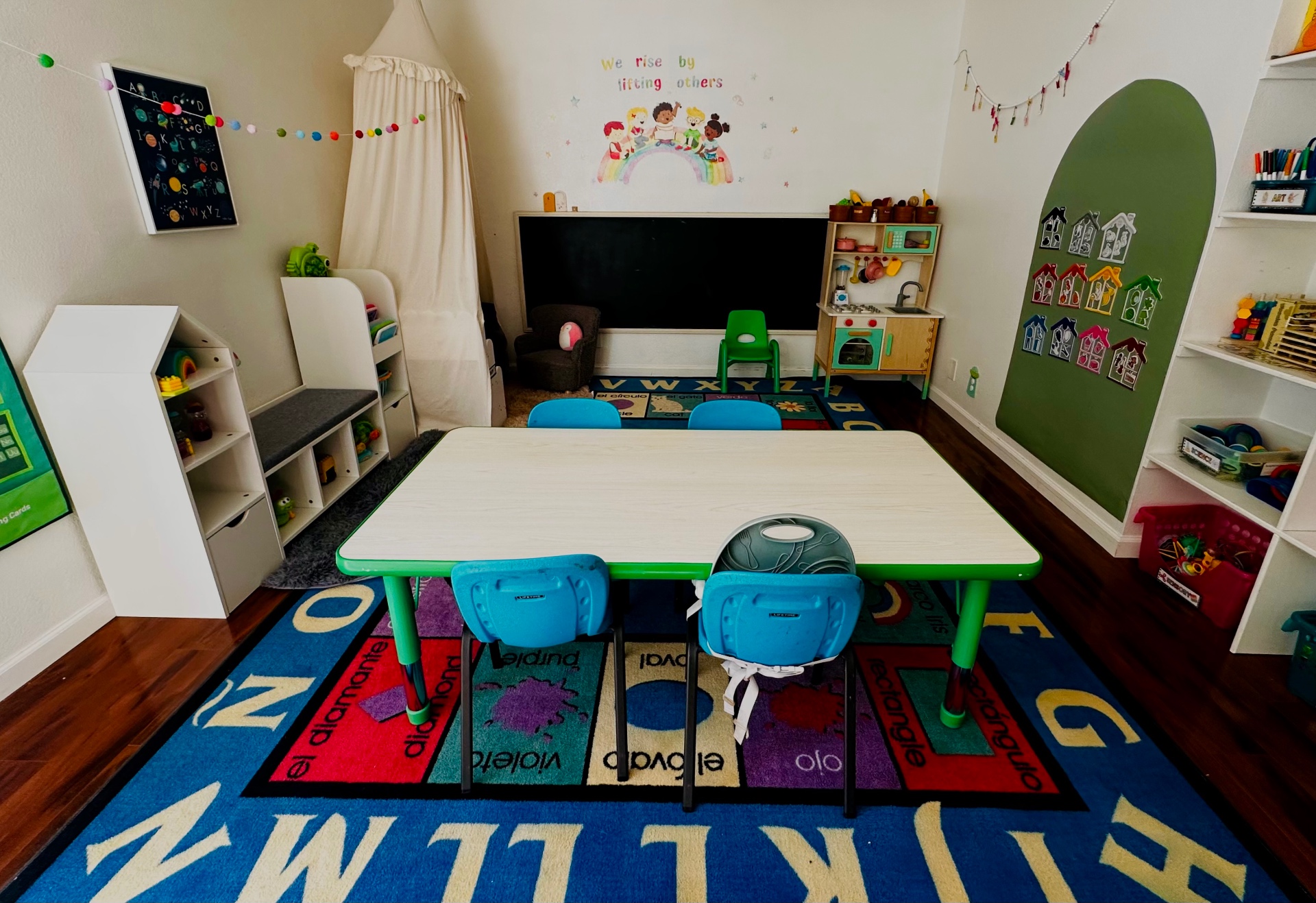 Classroom table with colorful chairs, alphabet rug and play kitchen